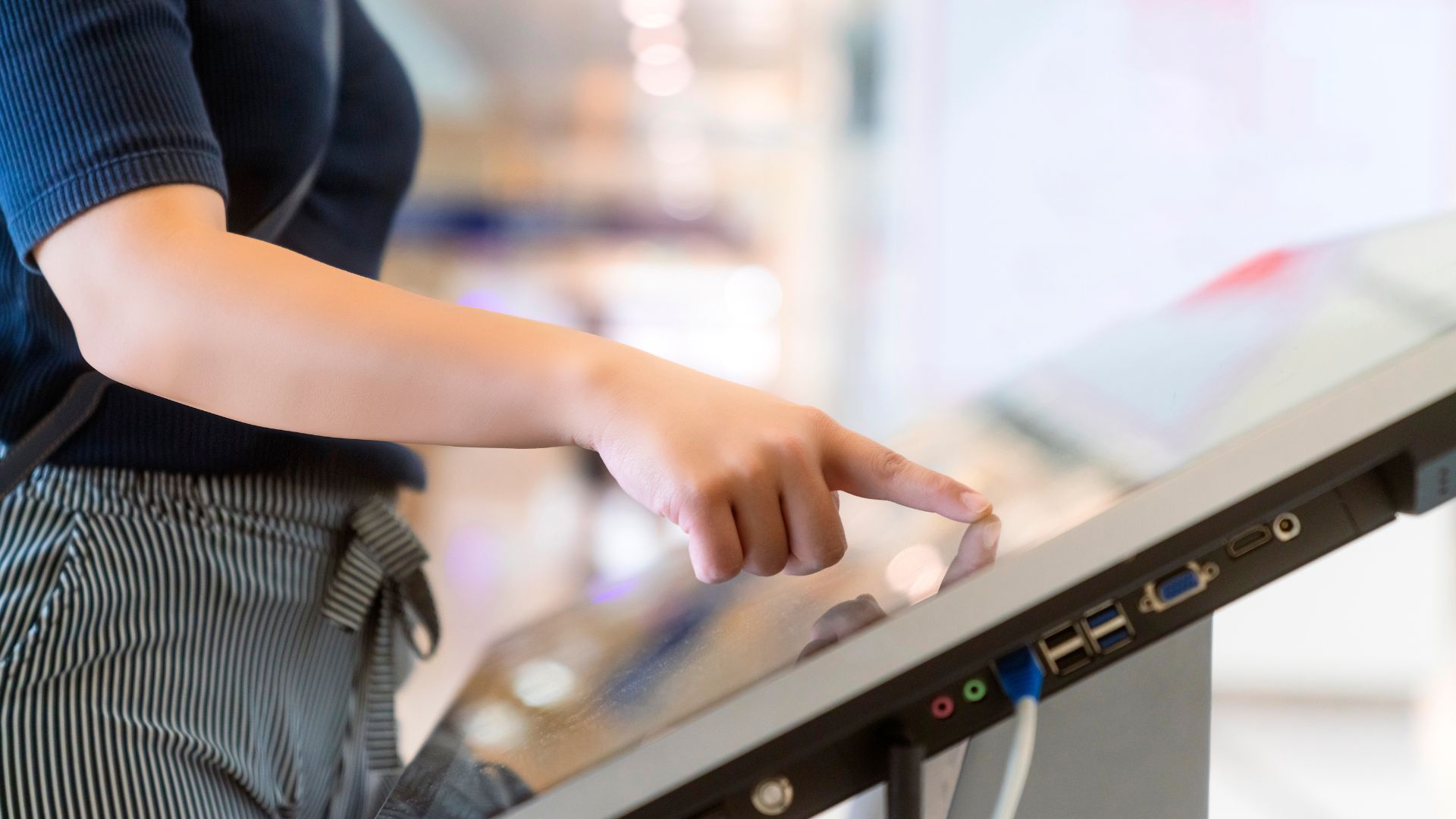 Client utilisant une borne tactile dans un magasin retail